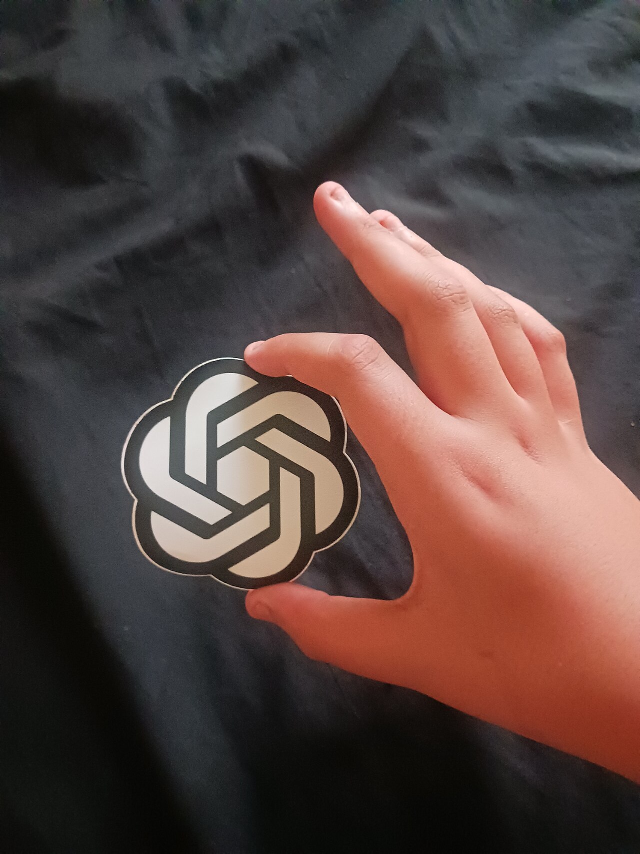 Le logo d'OpenAI tenu à la main