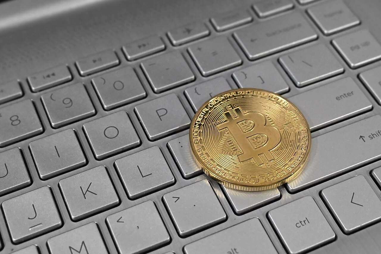 Pièce de bitcoin posée sur un clavier d'ordinateur