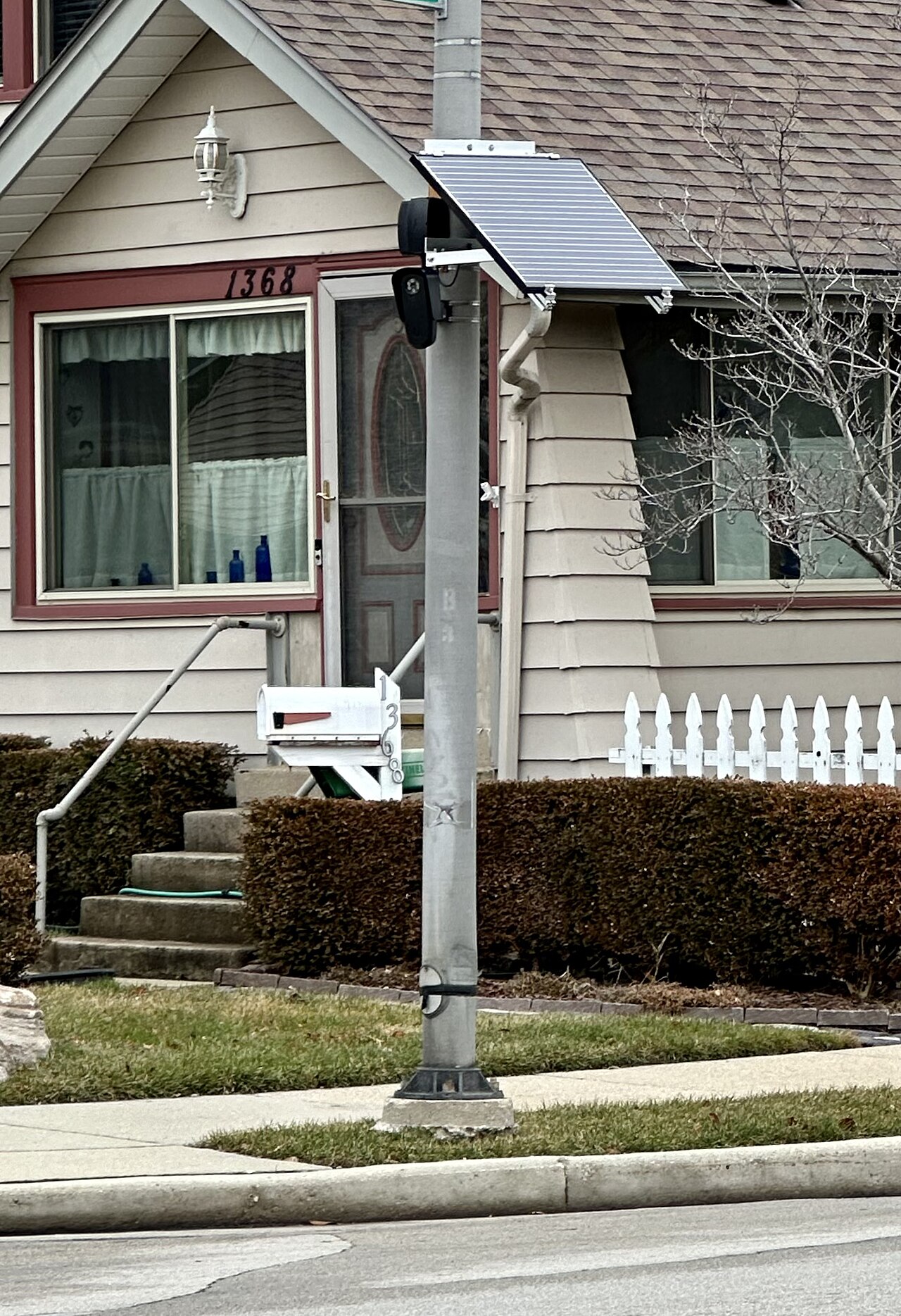 Une caméra Flock Safety sur un poteau, avec son panneau solaire